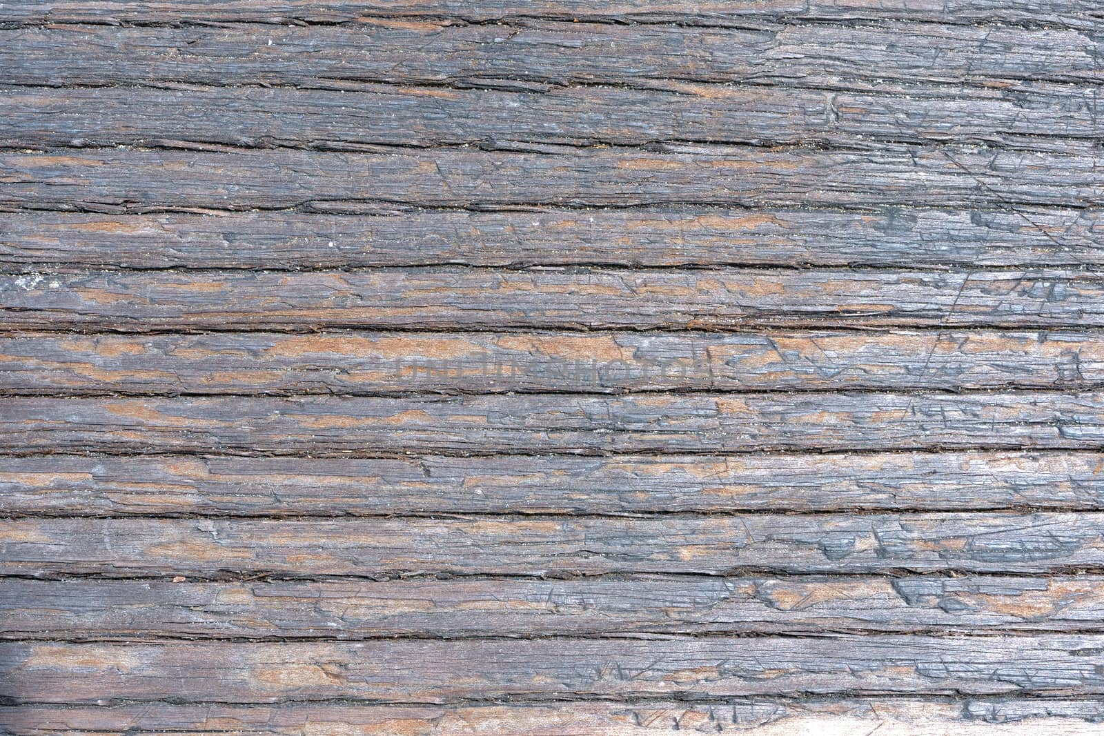 Closeup detail of old weathered and splintered wood showing deep grain and grains of sand and dirt