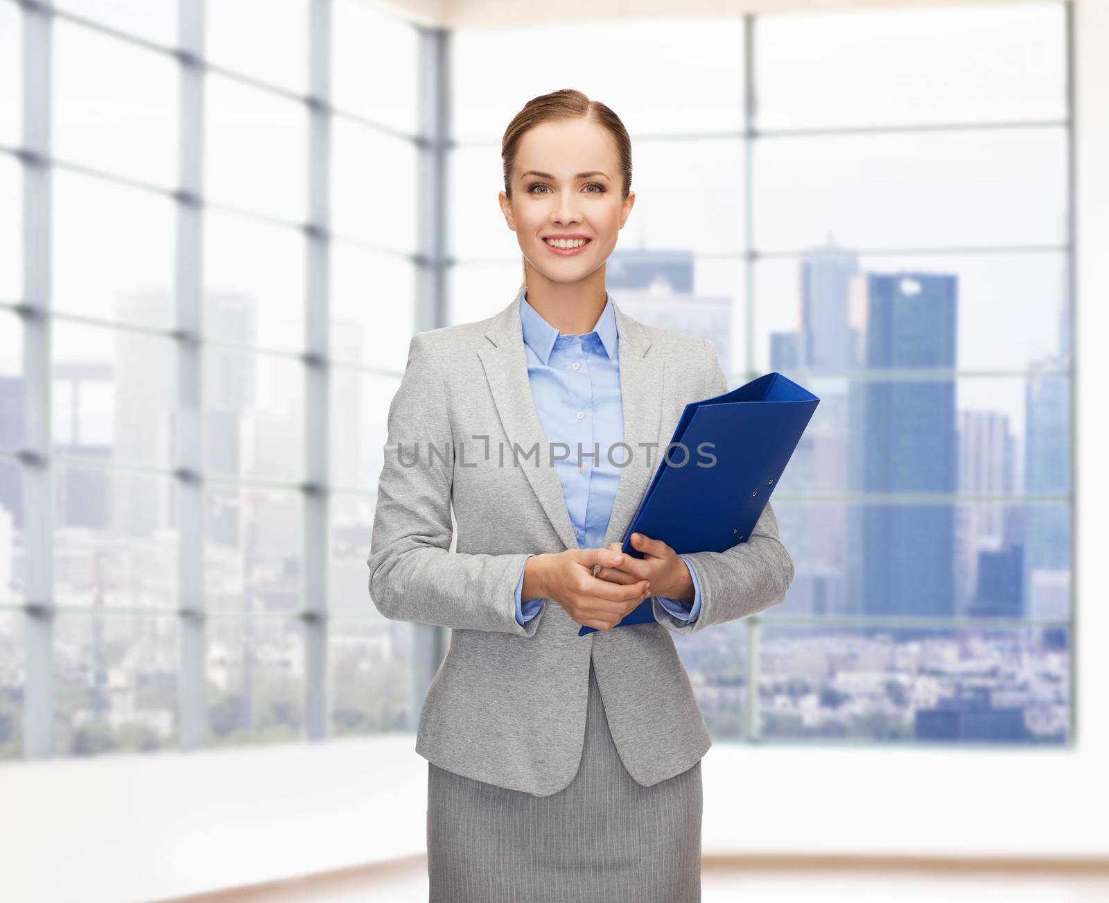 business, people, real estate and sale concept - smiling young businesswoman holding folder over office or empty city apartment background