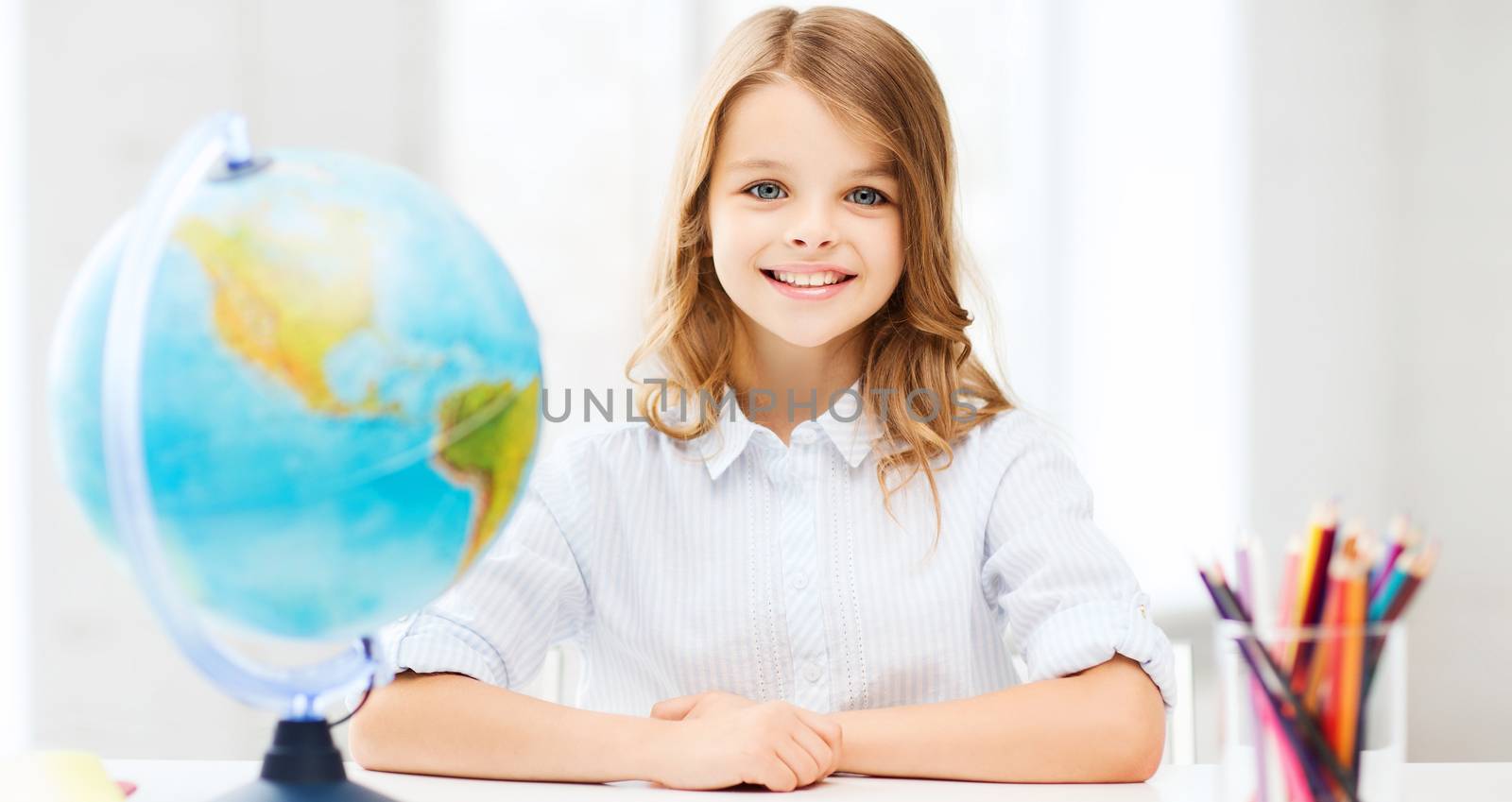 student girl with globe at school by dolgachov