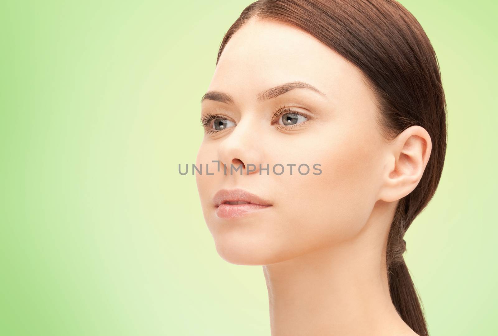 health, people, eco and beauty concept - beautiful young woman face over green background
