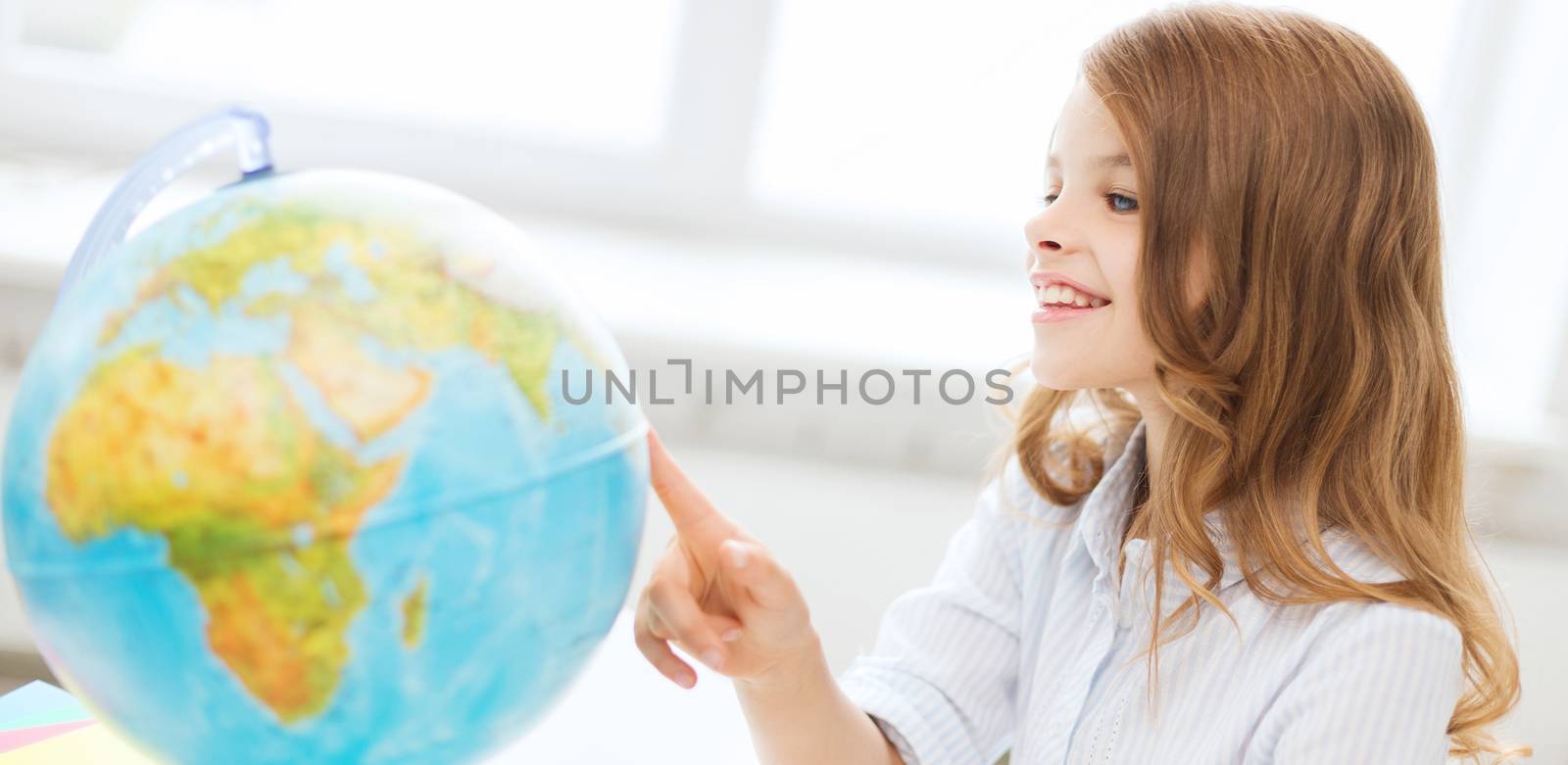 education and school concept - smilng little student girl with globe at school