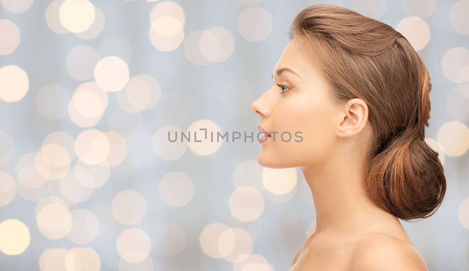 health, people, holidays, luxury and beauty concept - beautiful young woman face over lights background