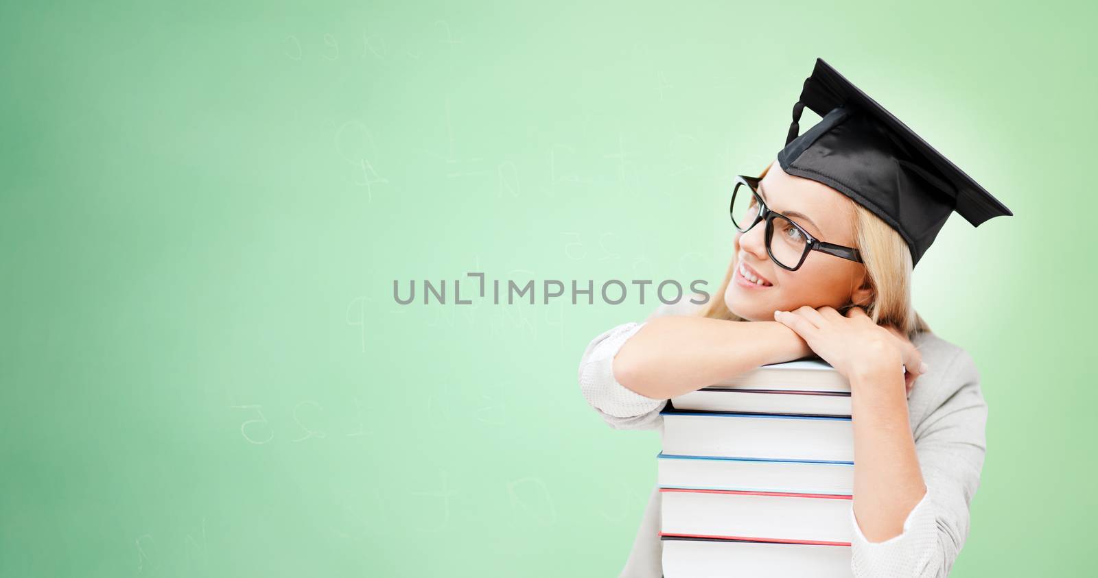 happy student in mortar board cap with books by dolgachov