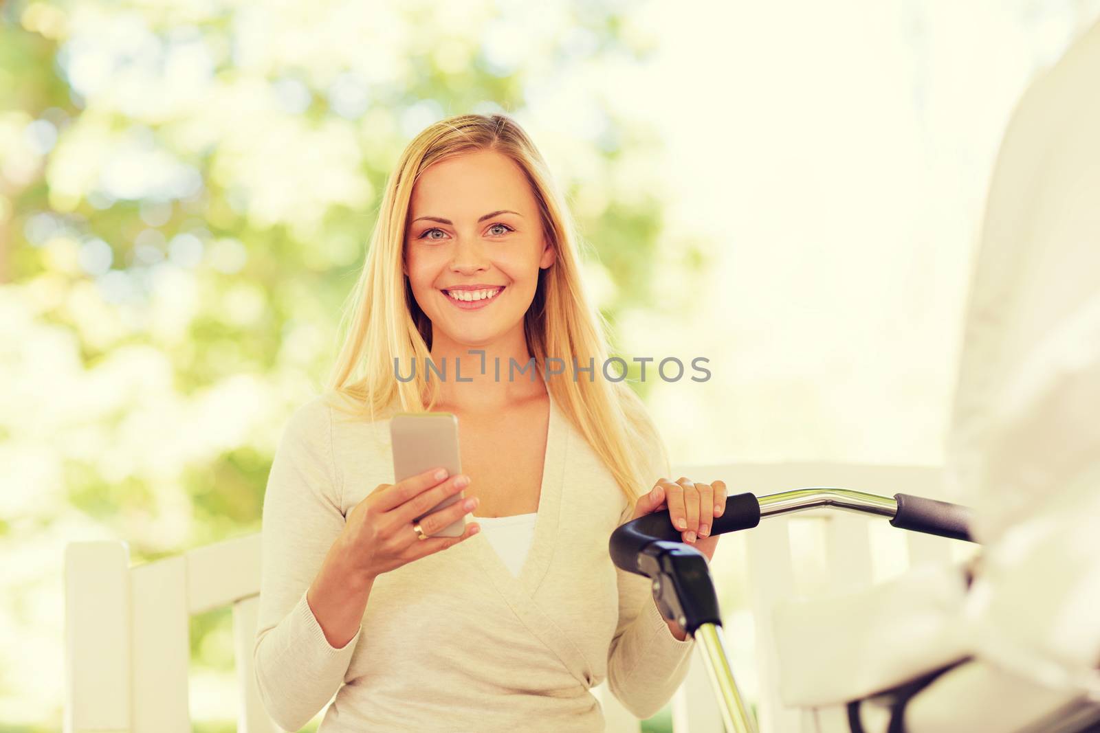 happy mother with smartphone and stroller in park by dolgachov