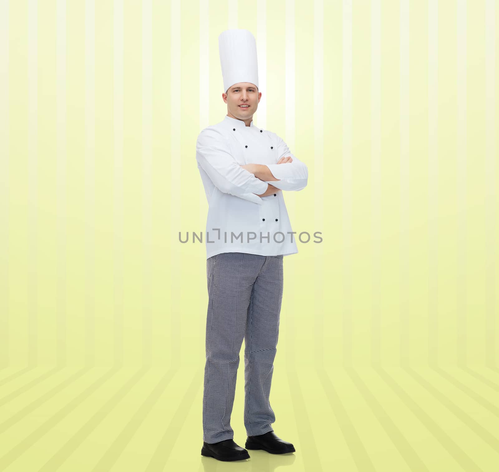 cooking, profession and people concept - happy male chef cook with crossed hands over yellow background