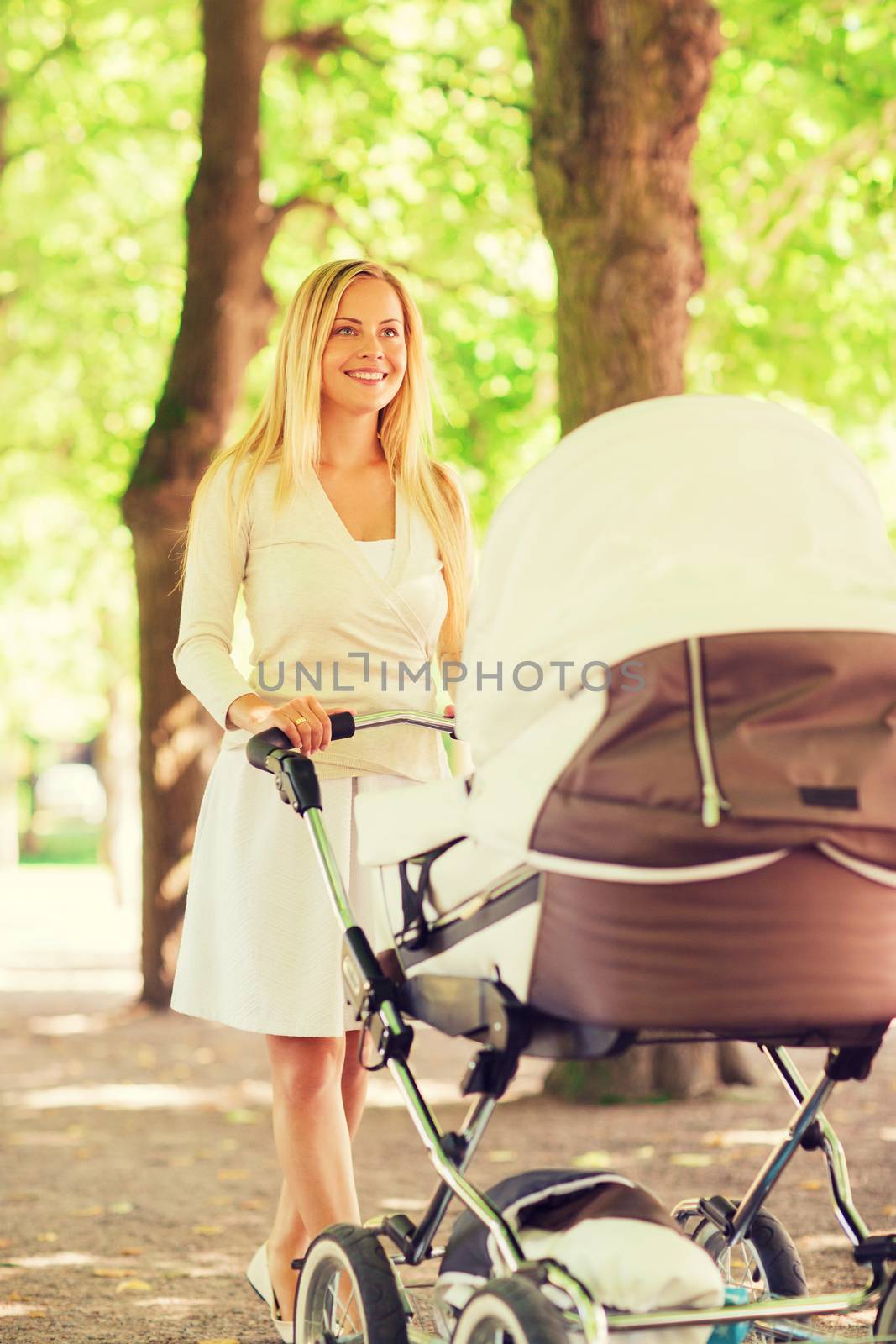 happy mother with stroller in park by dolgachov
