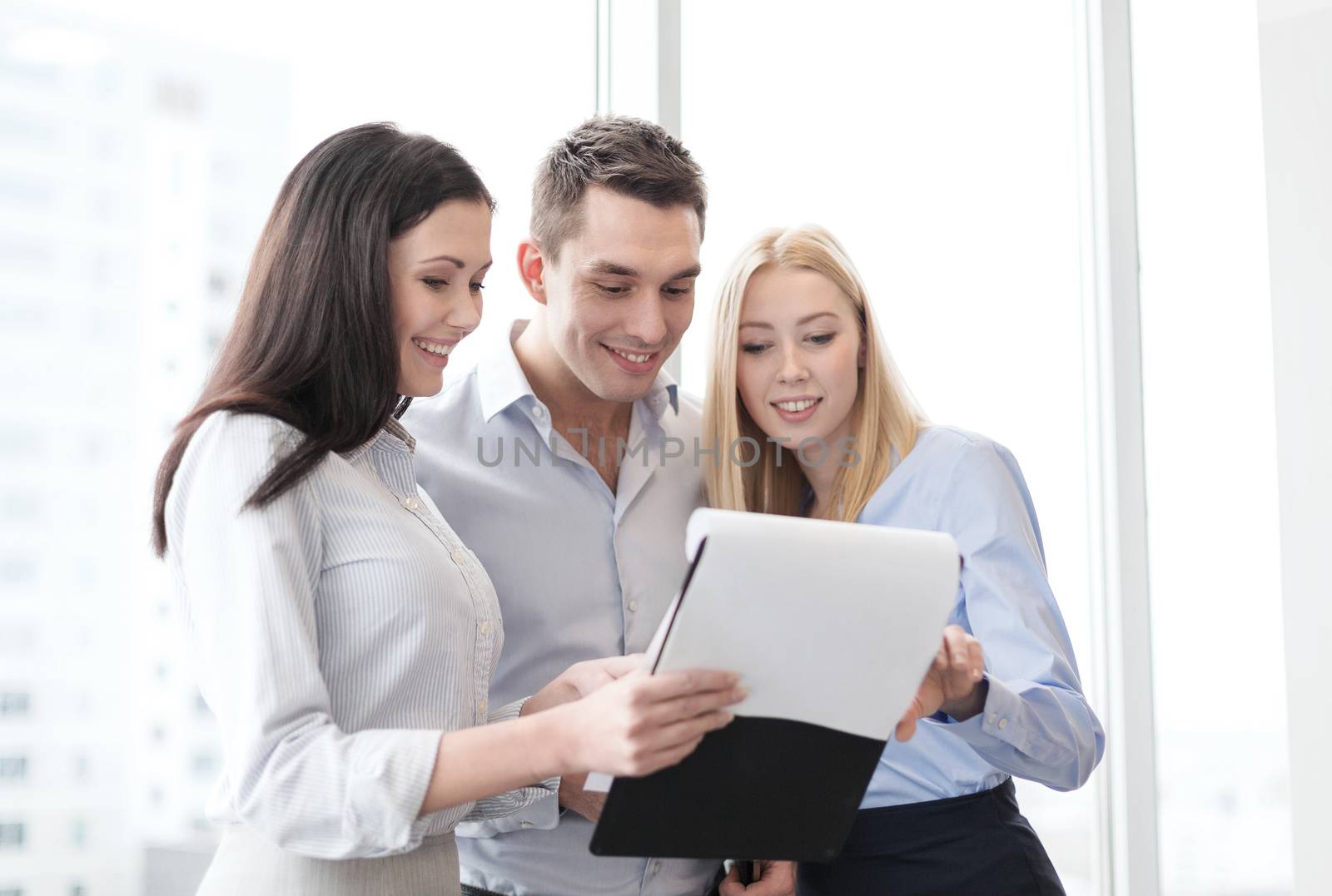 business and office concept - business team looking at clipboard