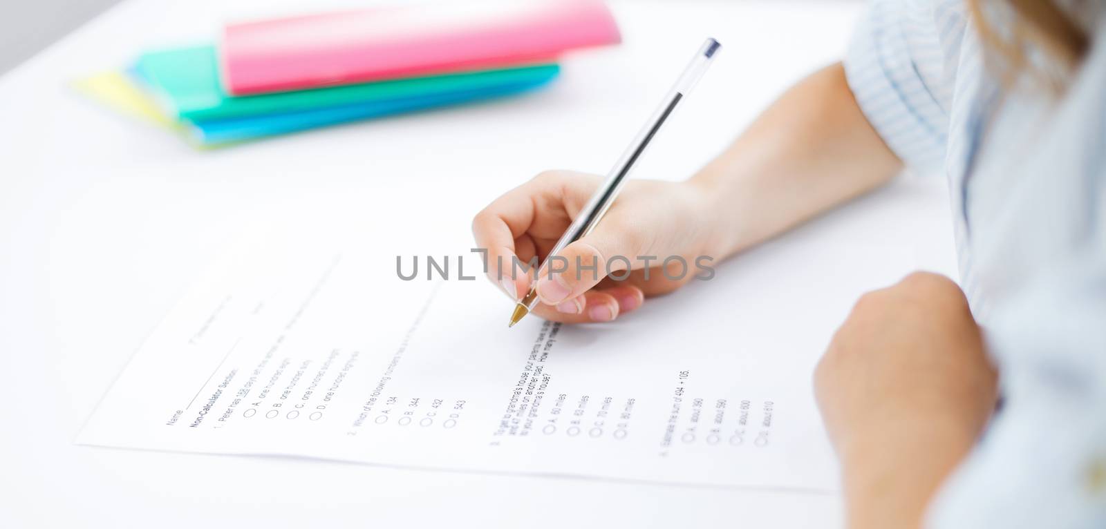 education, children and school concept - little student girl taking test