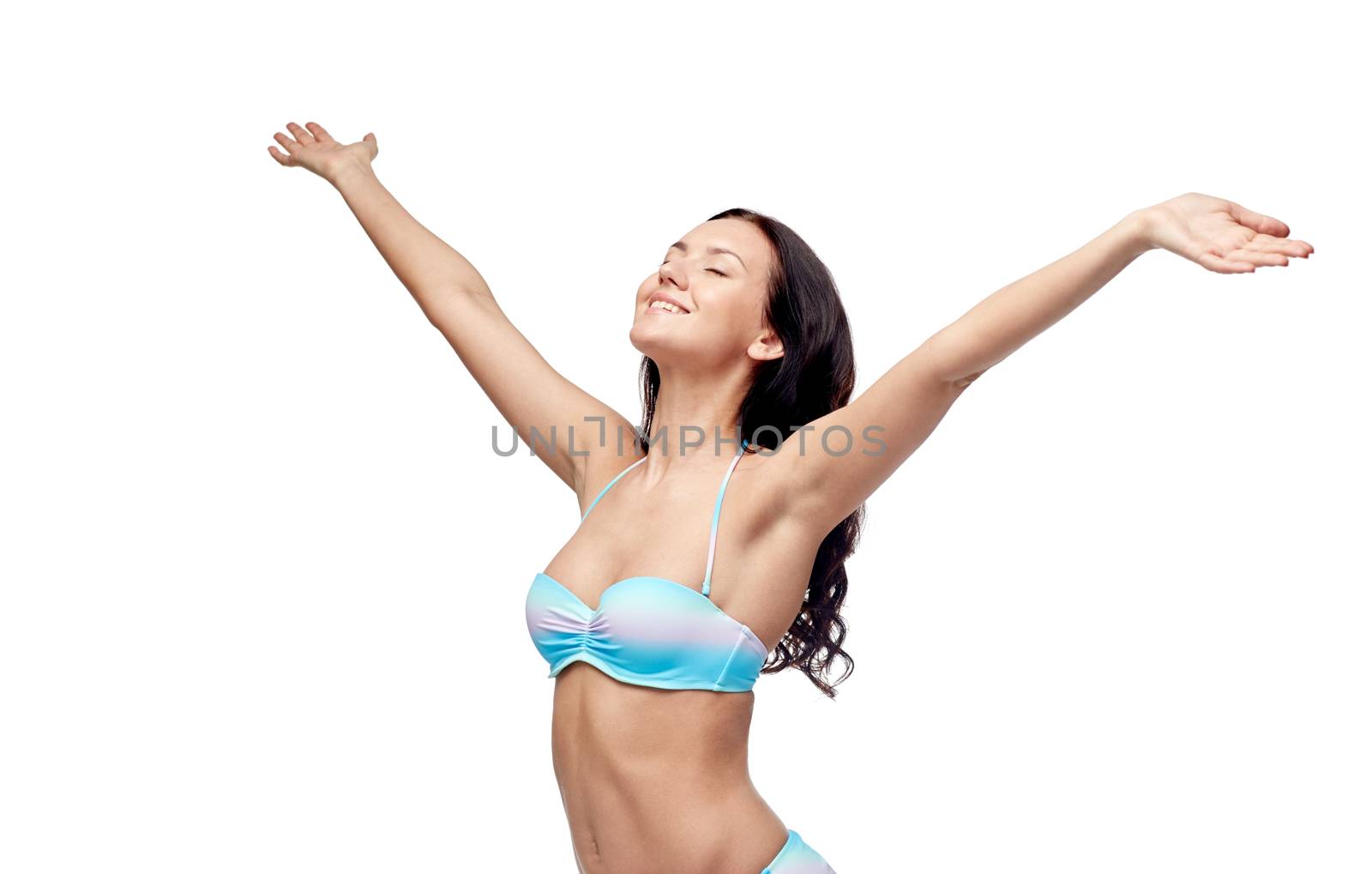 people, fashion, summer and beach concept - happy young woman in bikini swimsuit with raised hands looking up