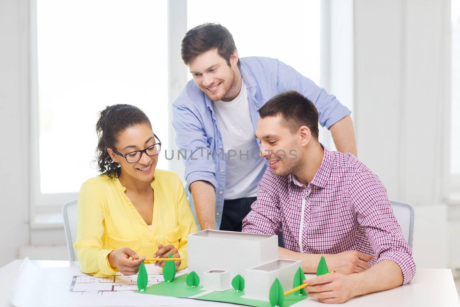 startup, education, architecture and office concept - smiling architects with house model and blueprint working in office