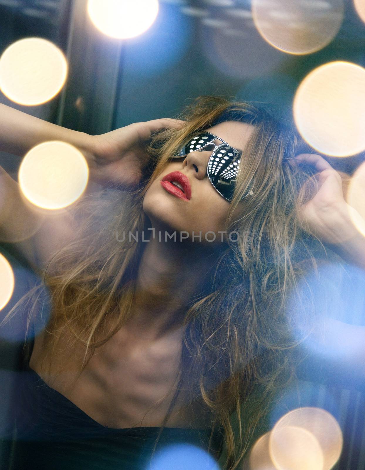 beautiful woman in sunglasses in elevator by dolgachov