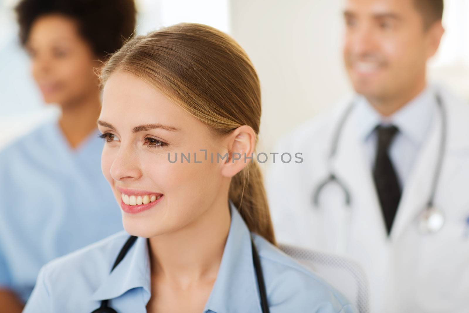 happy doctor over group of medics at hospital by dolgachov