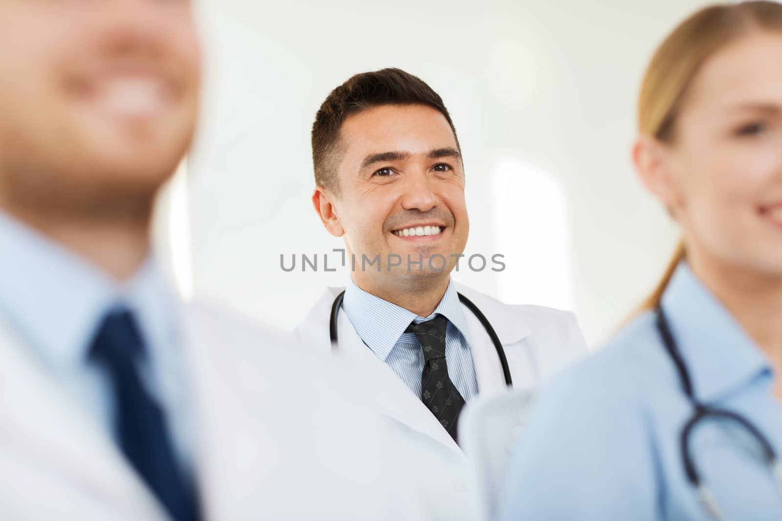 happy doctor over group of medics at hospital by dolgachov