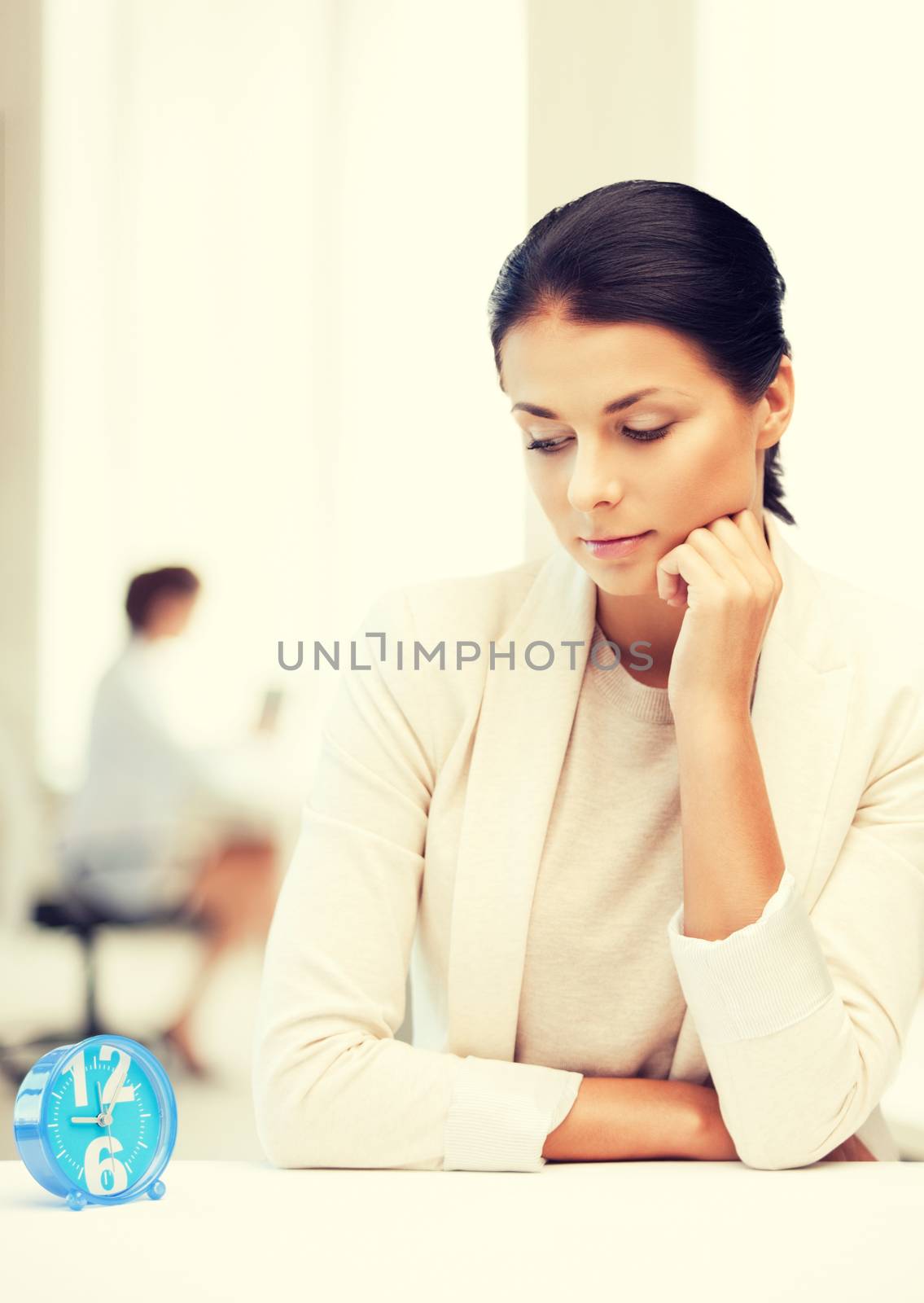 businesswoman looking at alarm clock by dolgachov