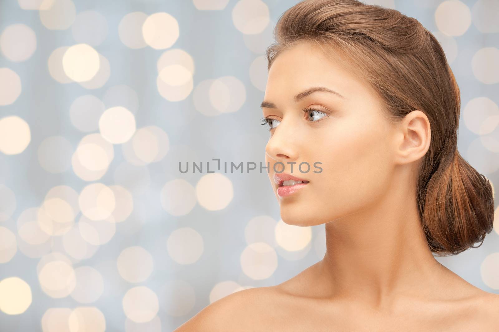 beauty, people, holidays, luxury and health concept - beautiful young woman face looking aside over lights background