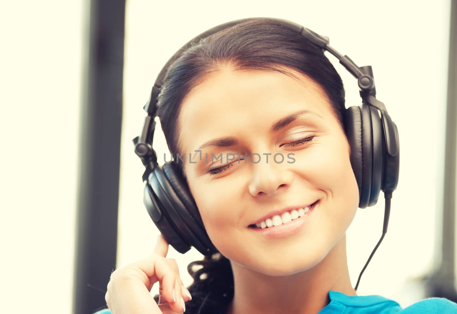 happy teenage girl in big headphones by dolgachov