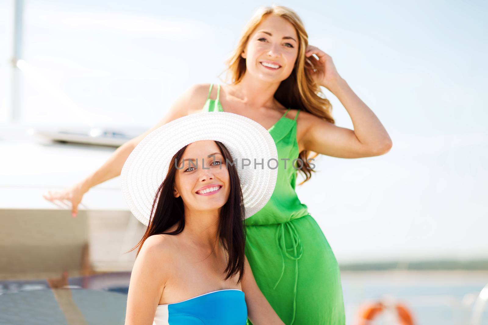 summer holidays and vacation concept - girls on boat or yacht