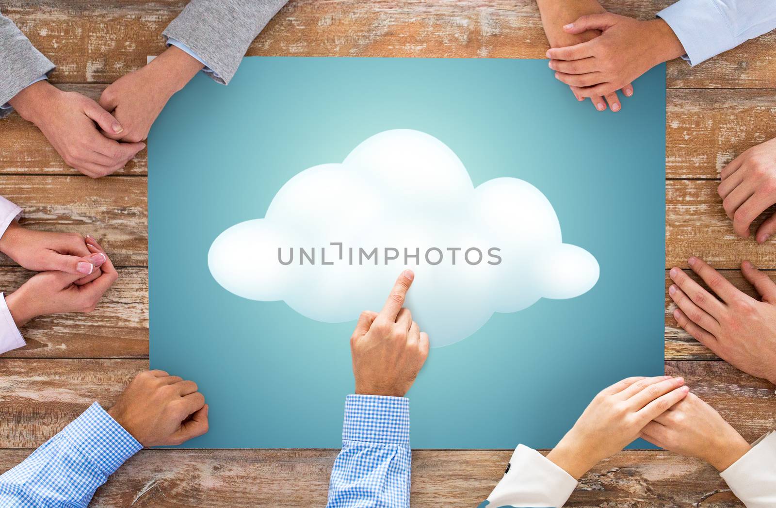 business, people and team work concept - close up of creative team hands at table pointing finger to cloud picture