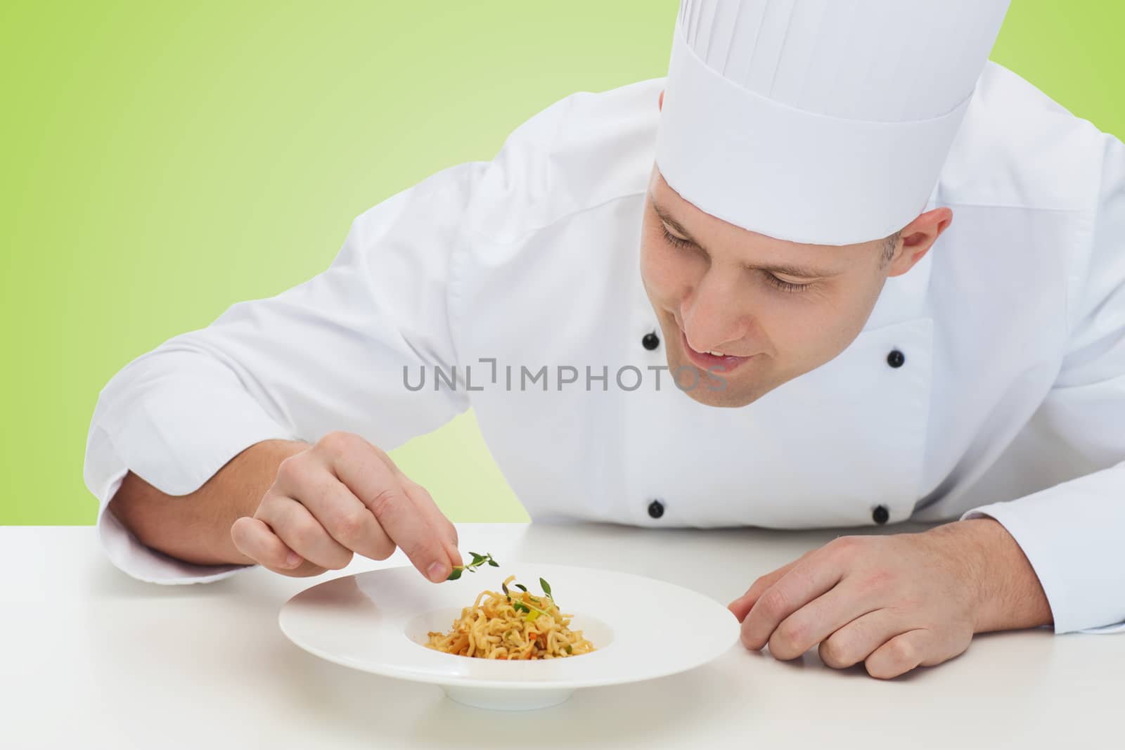 happy male chef cook decorating dish by dolgachov