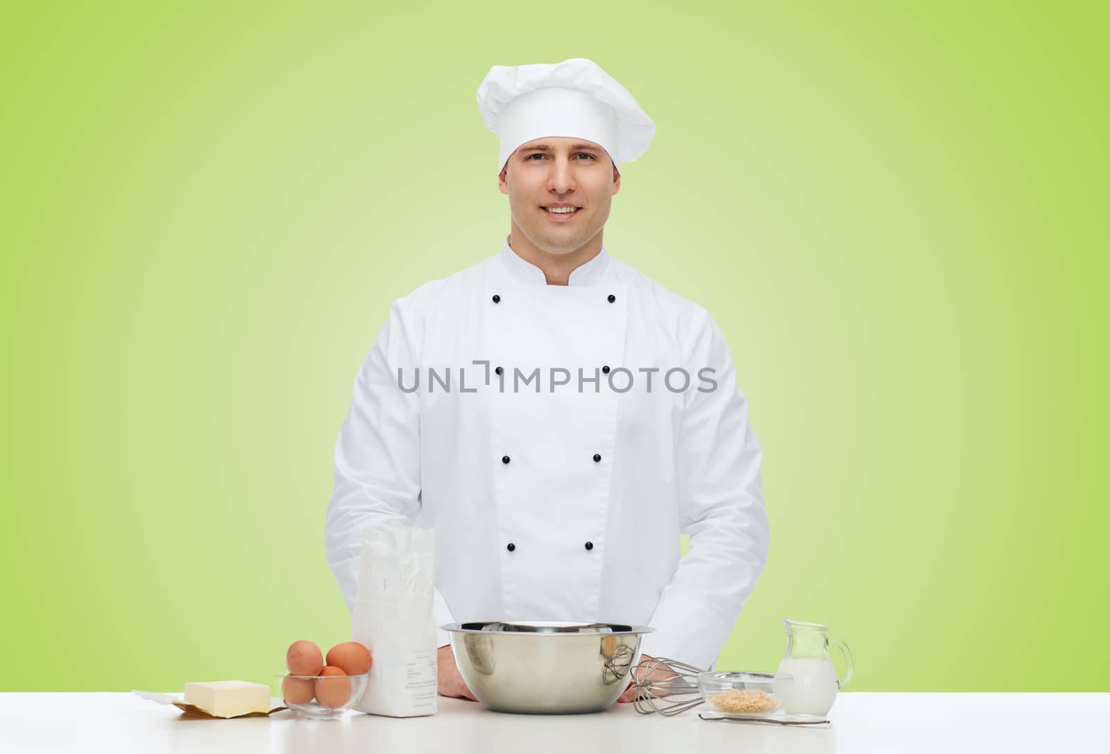 cooking, profession, haute cuisine, food and people concept - happy male chef cook baking over green background