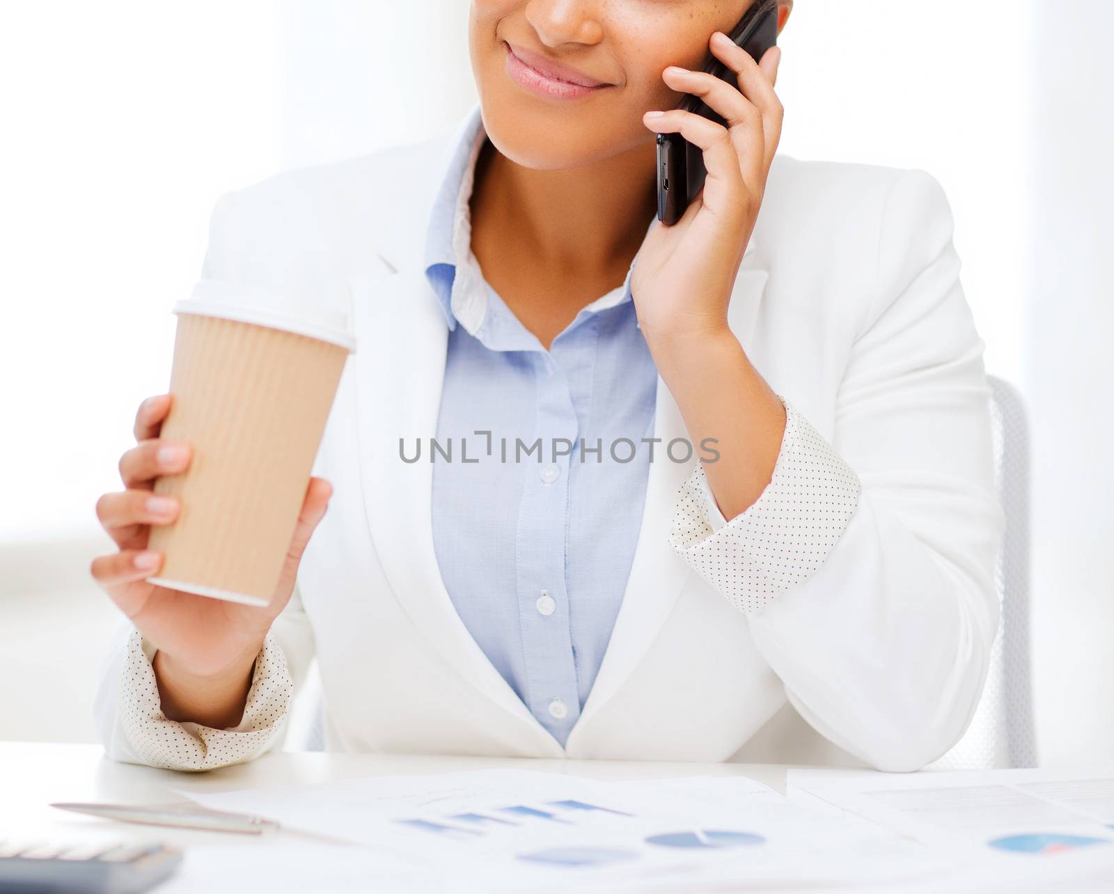 african businesswoman with smartphone in office by dolgachov