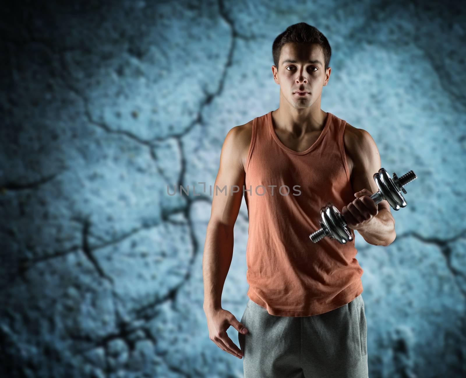 sport, fitness, weightlifting, bodybuilding and people concept - young man with dumbbell flexing biceps over concrete wall background