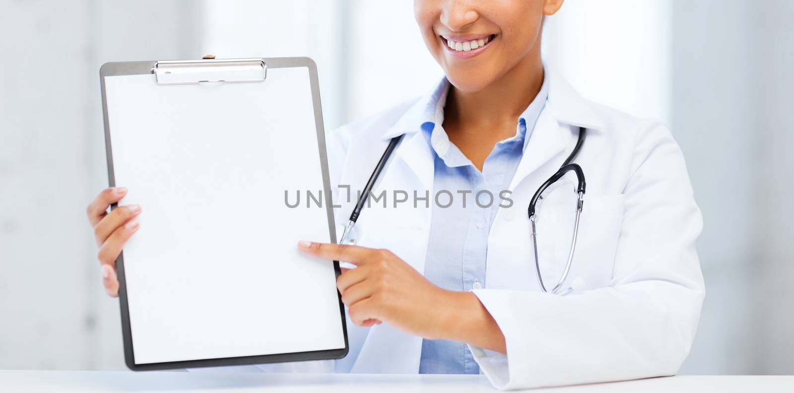 health care and medical concept - female doctor with stethoscope and blank prescription