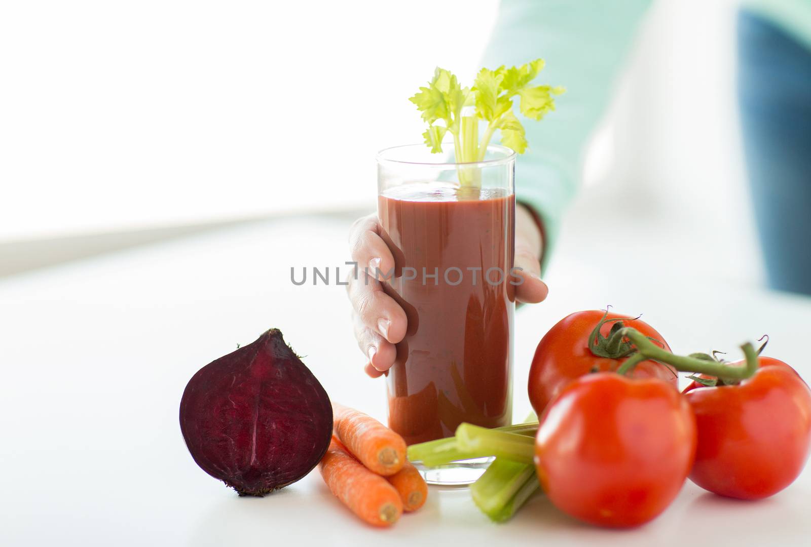 close up of woman hands with juice and vegetables by dolgachov