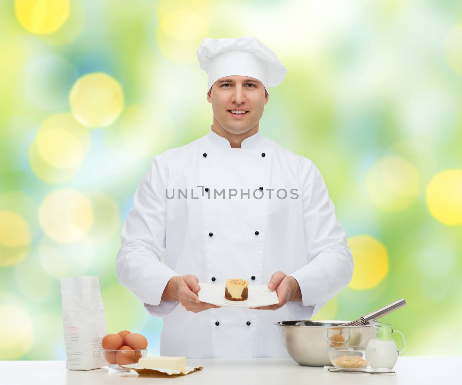 cooking, profession, haute cuisine, food and people concept - happy male chef cook baking dessert over green lights background