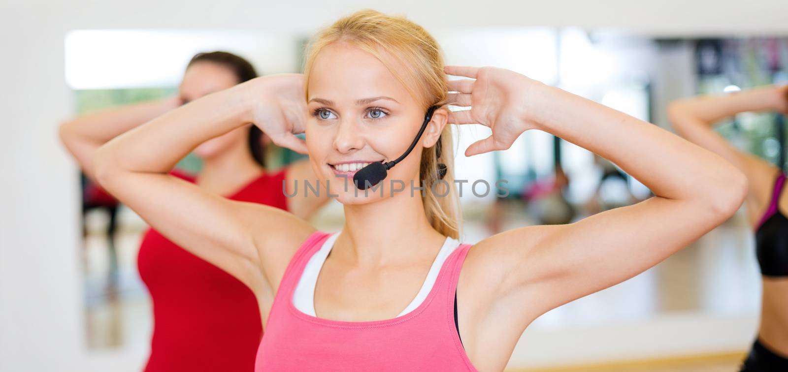 group of smiling people exercising in the gym by dolgachov