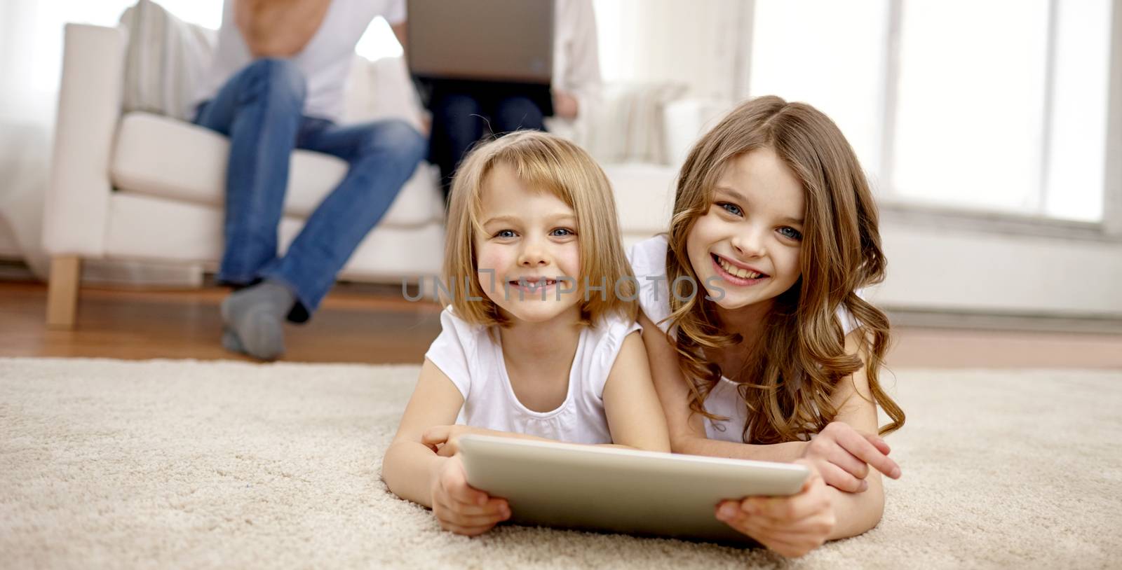 happy little girls with tablet pc computer at home by dolgachov