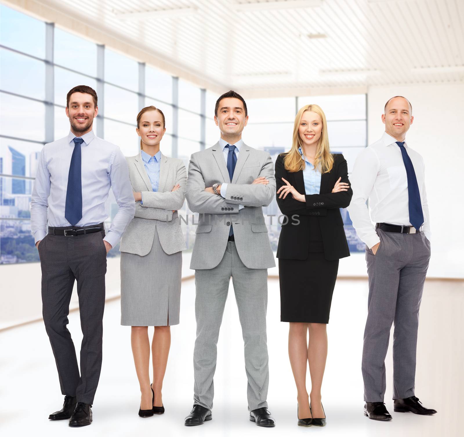 business, people, gesture and teamwork concept - group of smiling businessmen over office room background