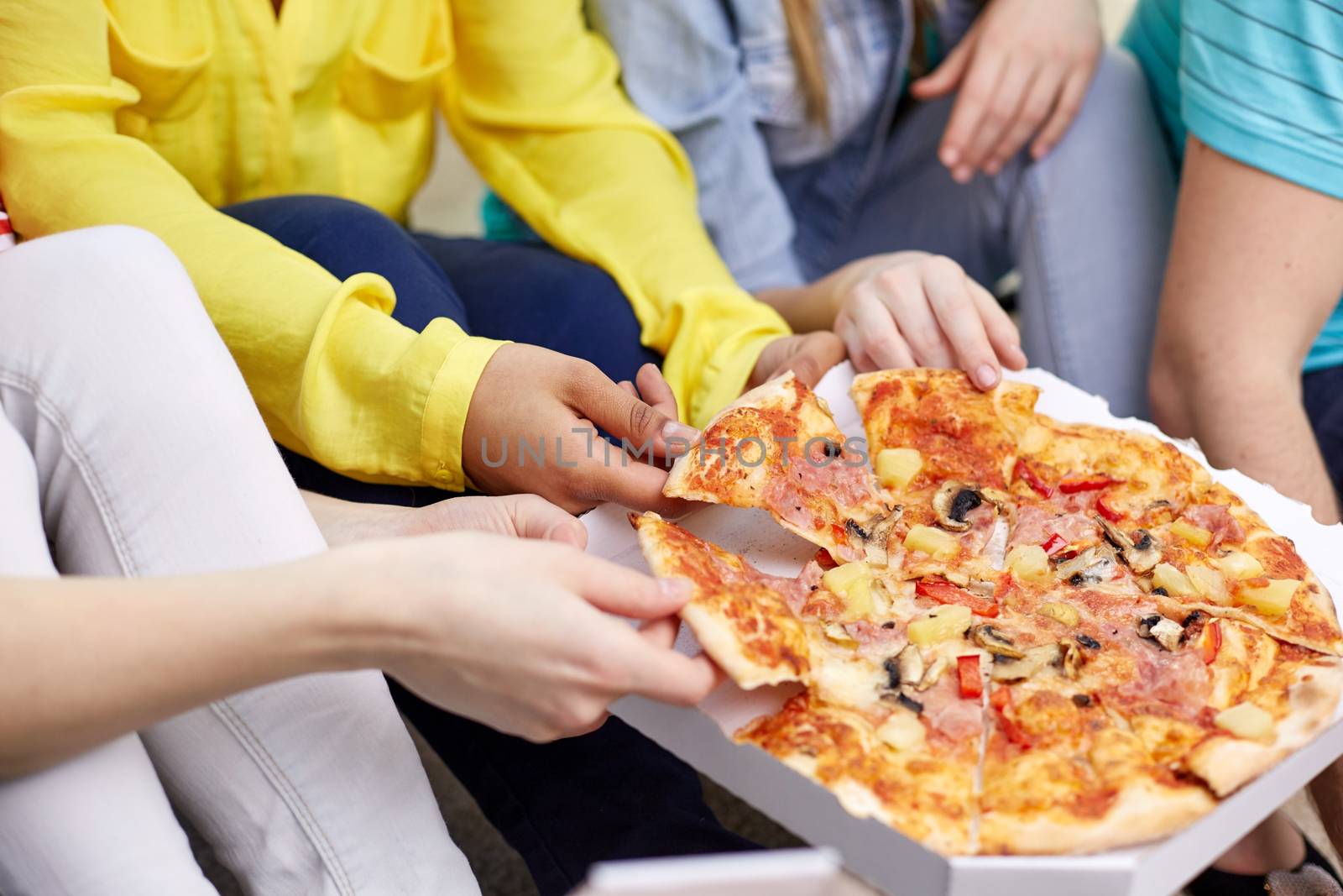 food, leisure and friendship concept - close up of happy teenage friends eating pizza at home