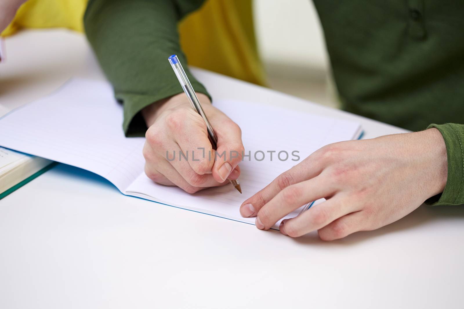 close up of male hands writing to notebook by dolgachov