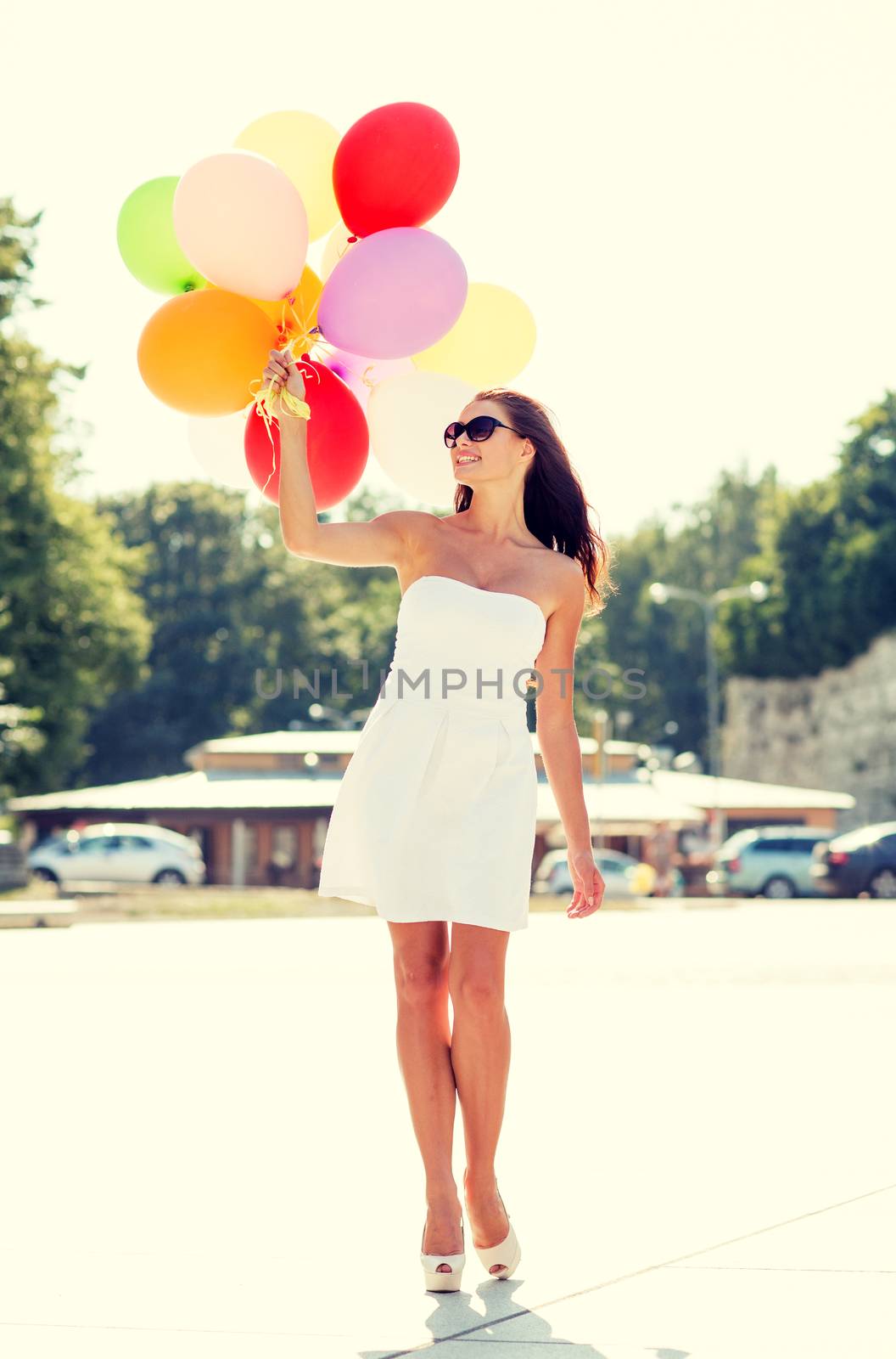 smiling young woman in sunglasses with balloons by dolgachov