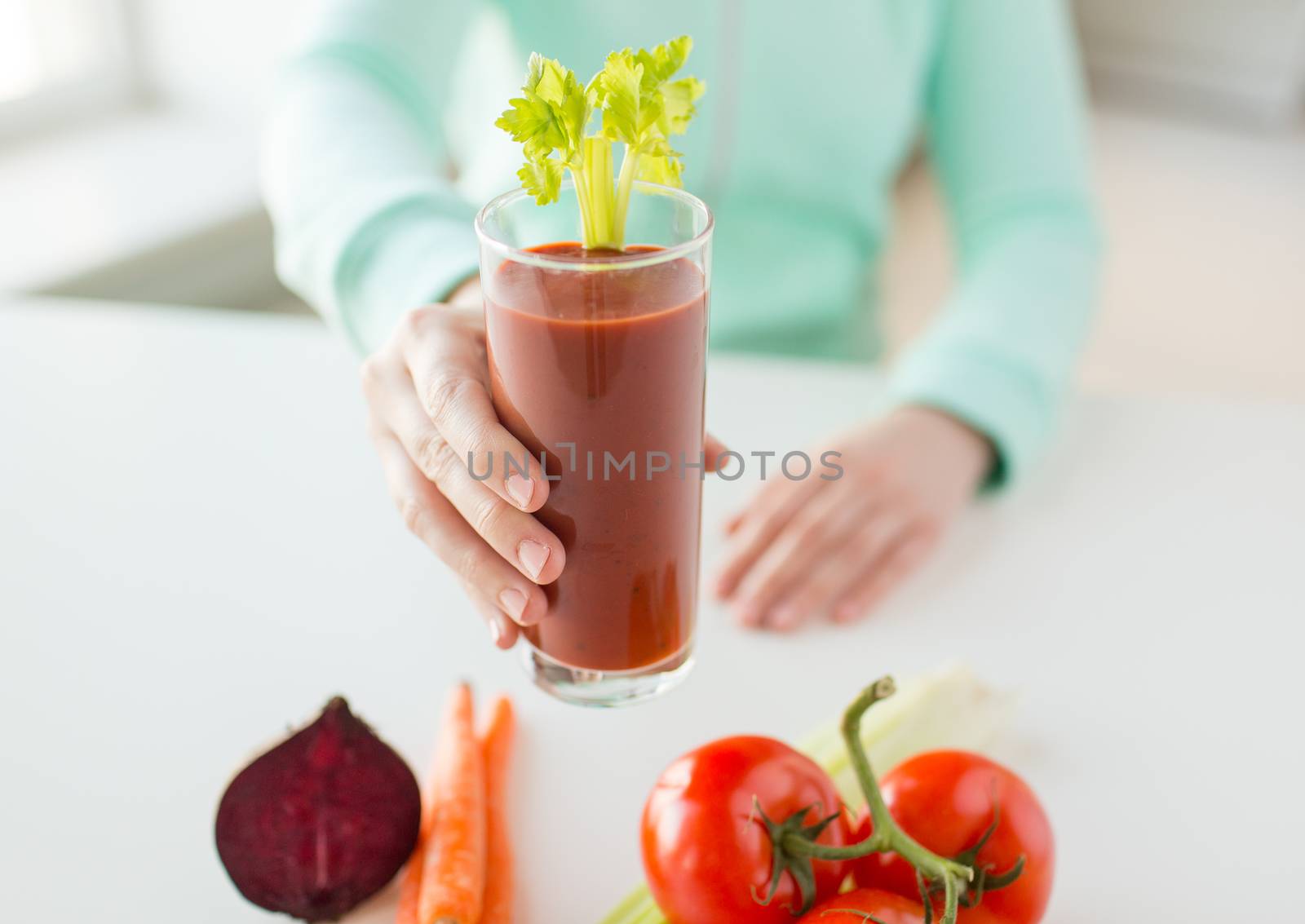 close up of woman hands with juice and vegetables by dolgachov