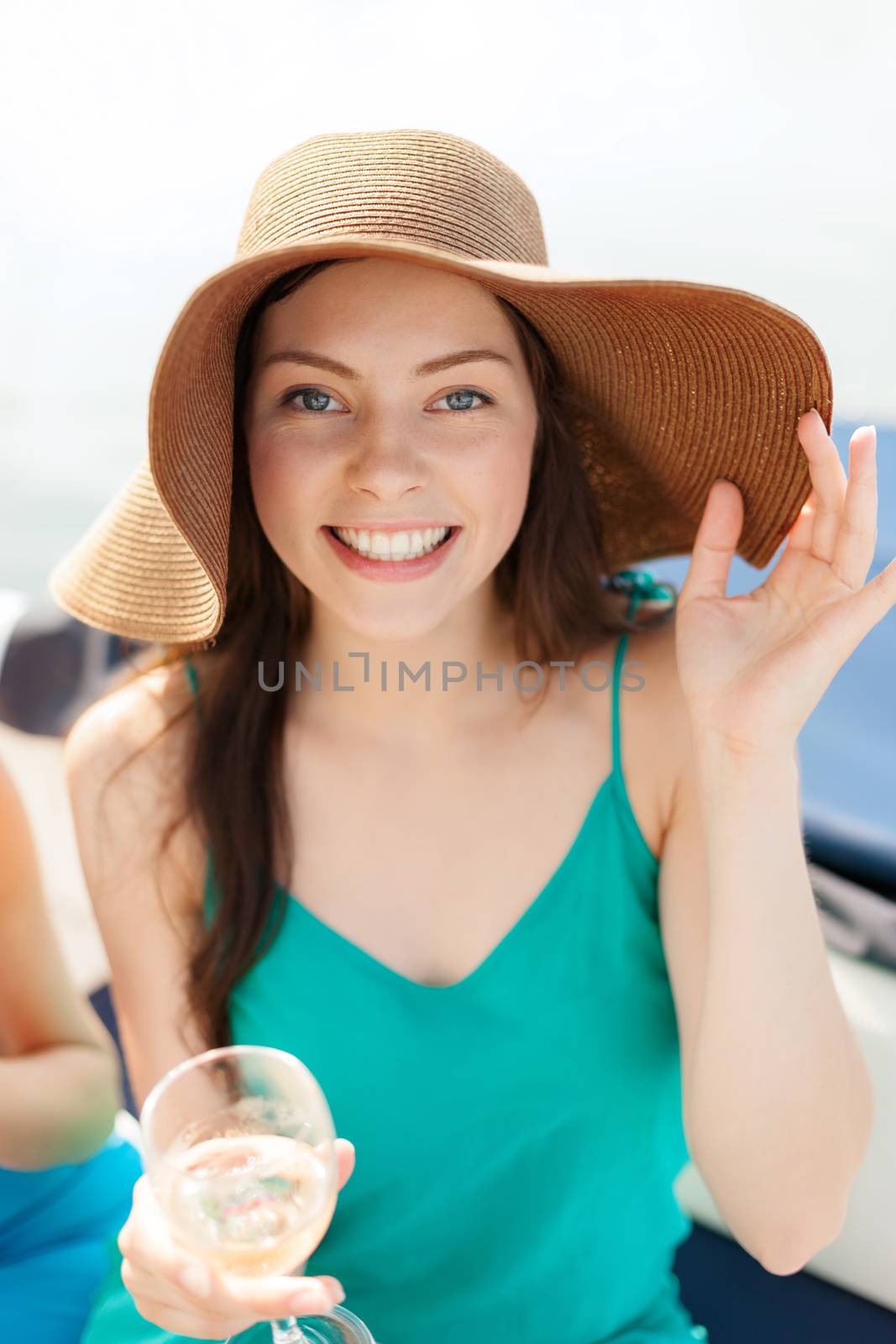 summer holidays, vacation and celebration concept - smiling girl in hat with champagne glass