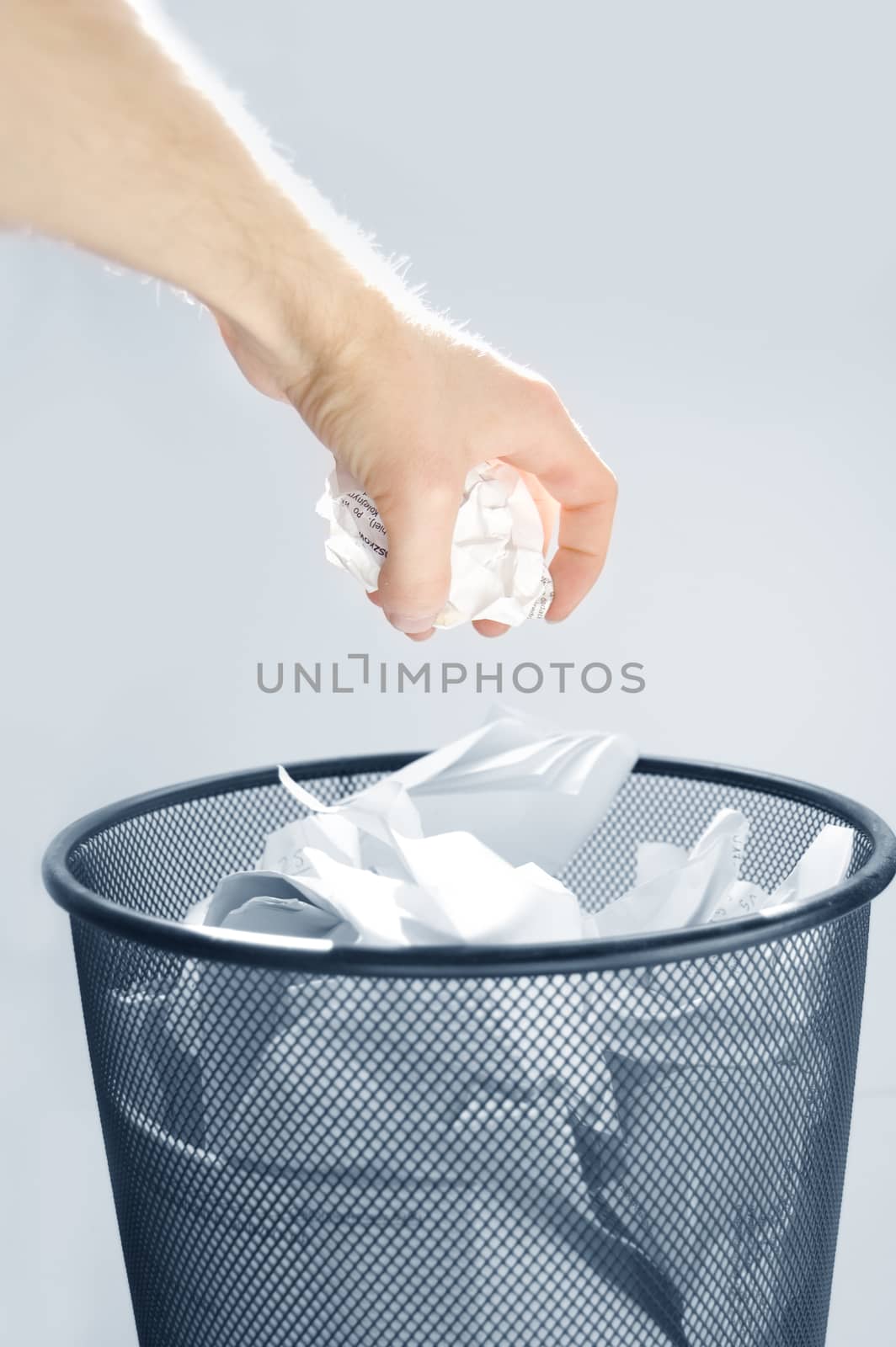 Garbage conceptual image. Man throws paper into a full garbage.