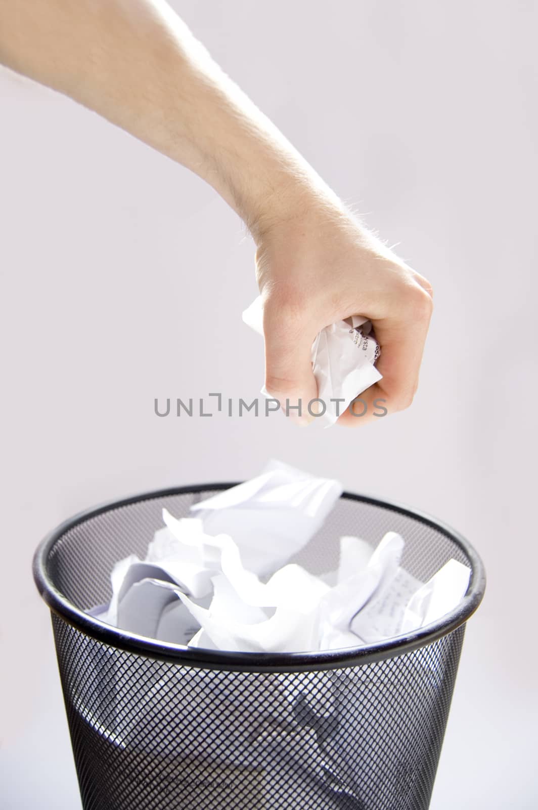 Garbage conceptual image. Man throws paper into a full garbage.