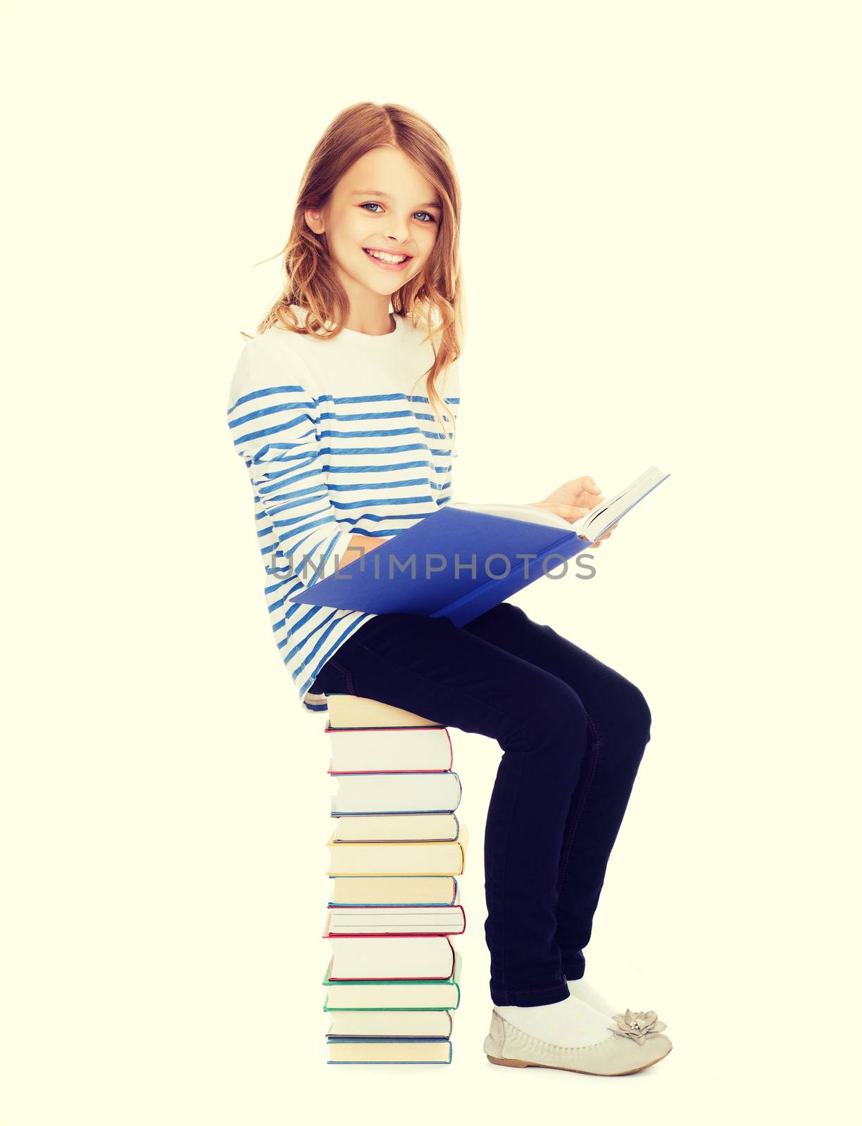 little student girl sitting on stack of books by dolgachov