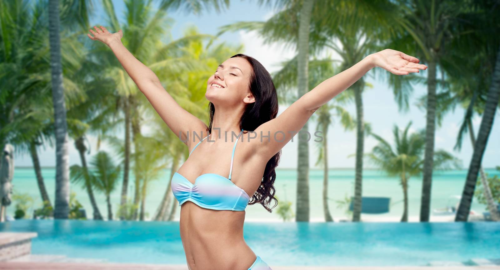 happy woman in bikini swimsuit with raised hands by dolgachov
