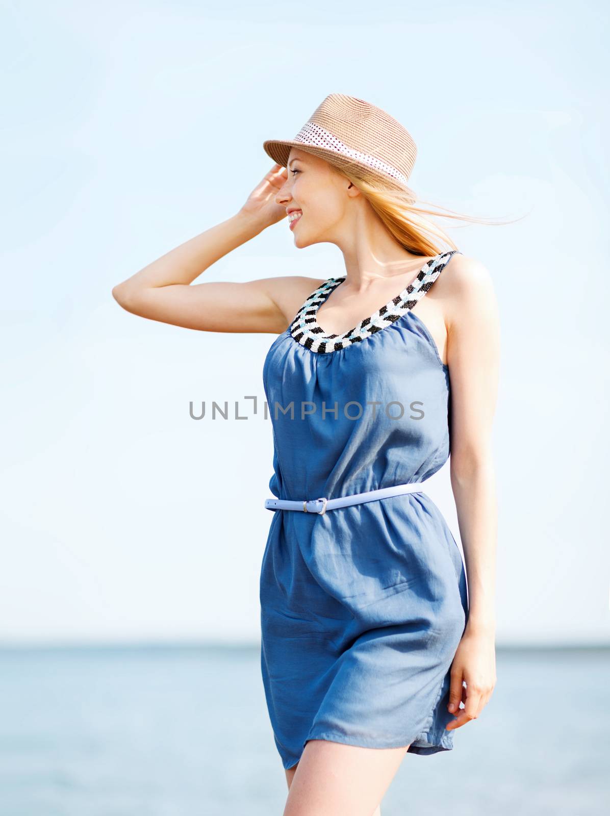 girl in hat walking on the beach by dolgachov