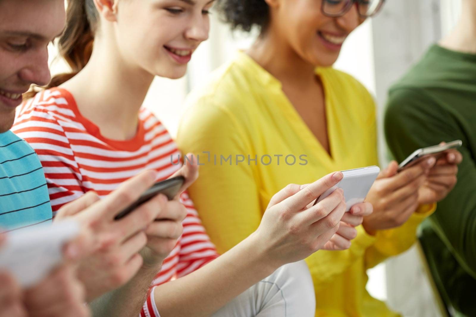 close up of students with smartphones at school by dolgachov