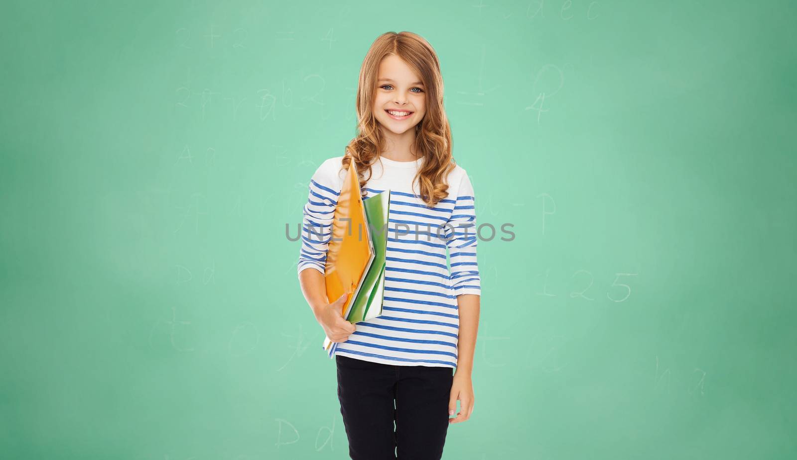 education, people, children and school concept - happy girl holding colorful folders over green board background