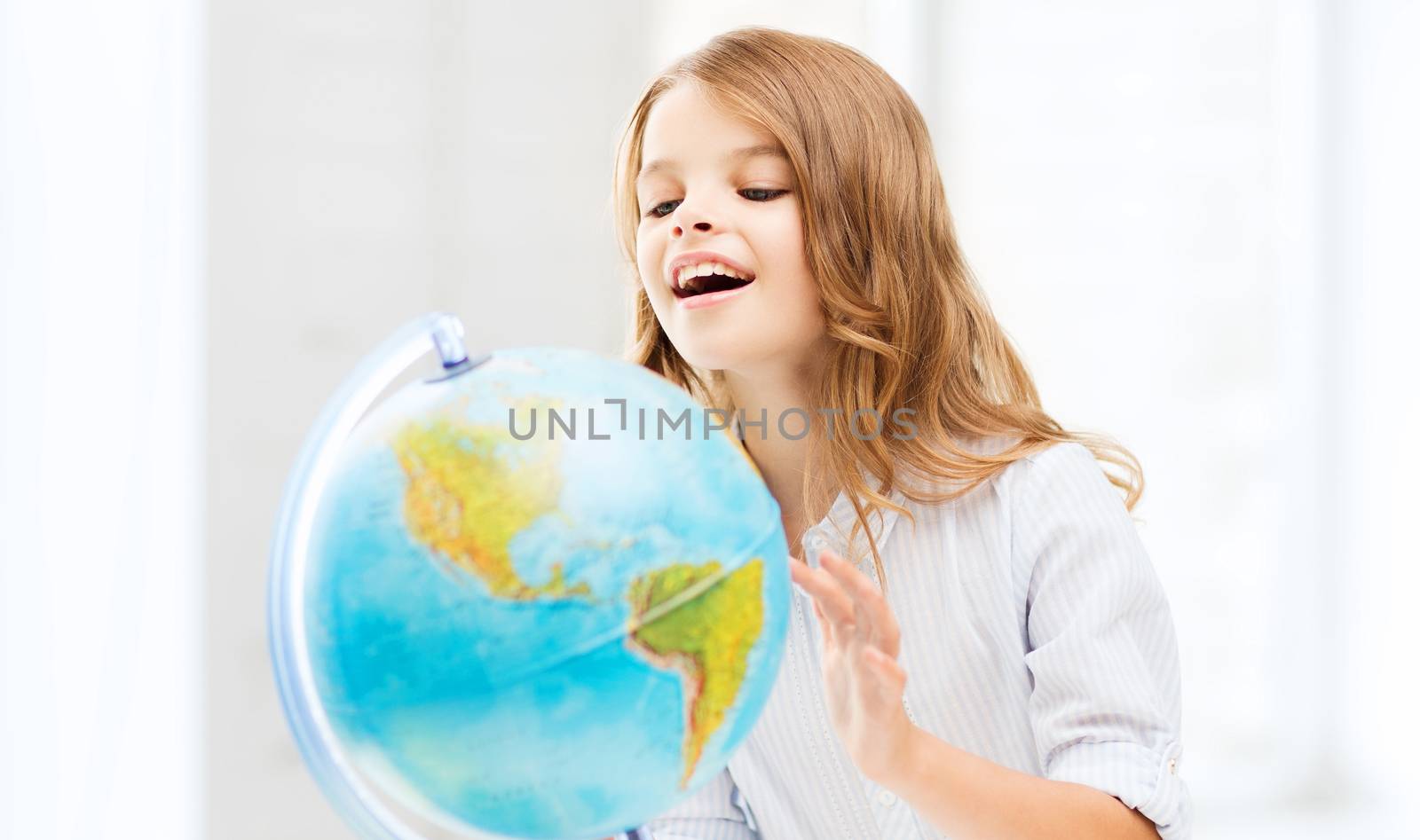 education and school concept - little student girl with globe at school