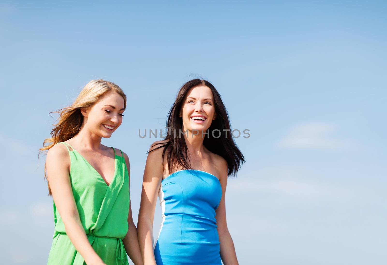 summer holidays and vacation - girls walking on the beach