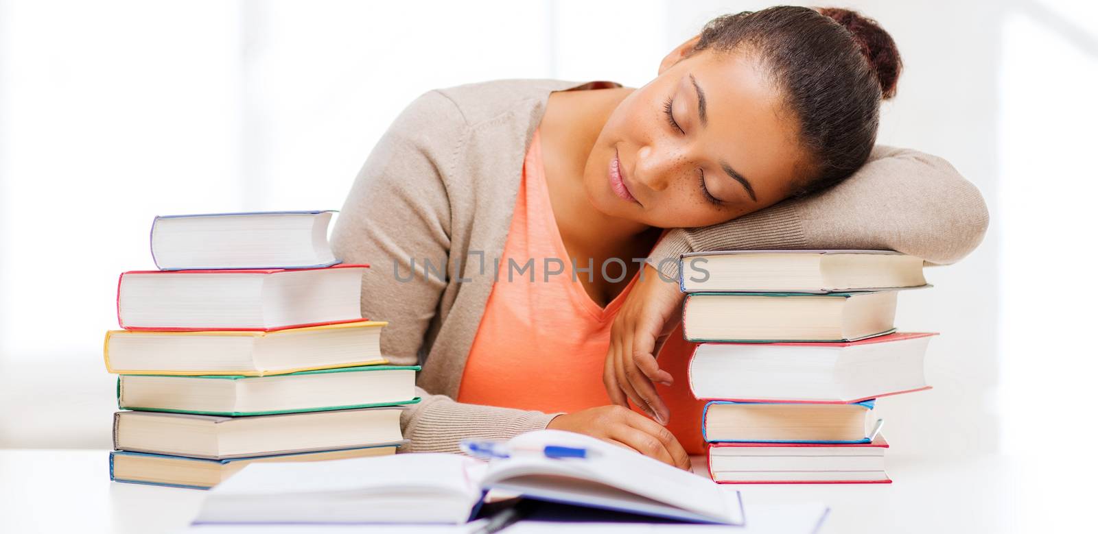 education and business concept - tired student with pile of books and notes studying indoors