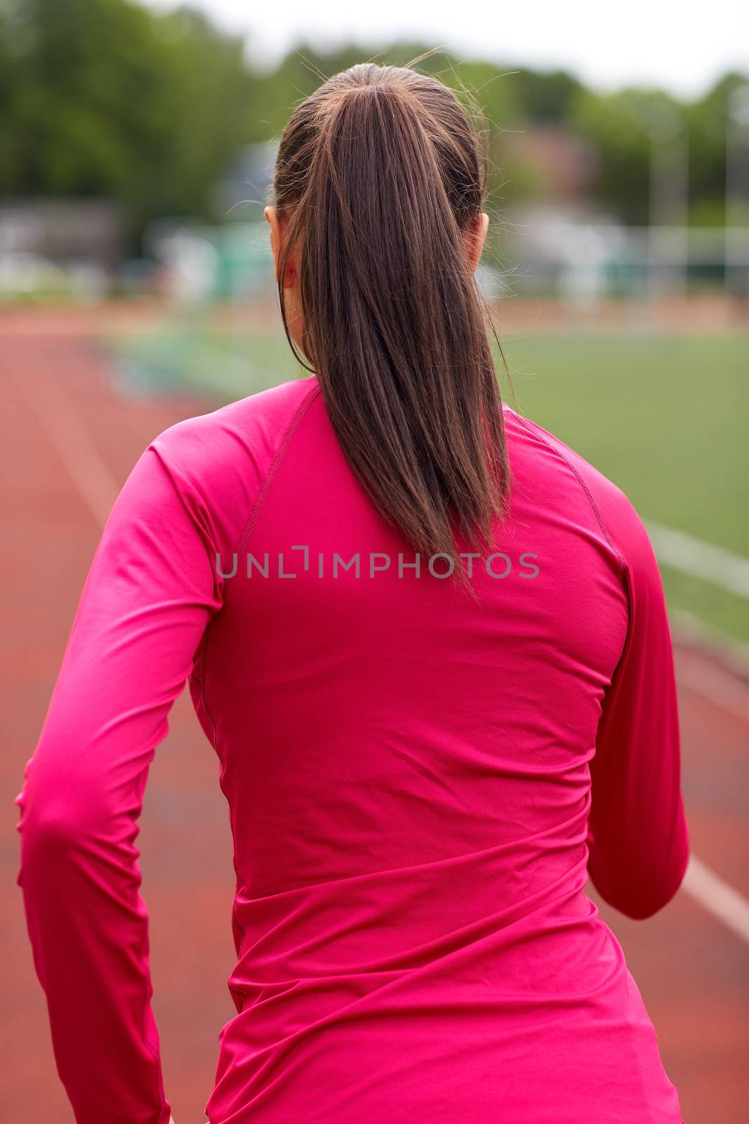 fitness, sport, training, people and lifestyle concept - african american woman running on track outdoors from back