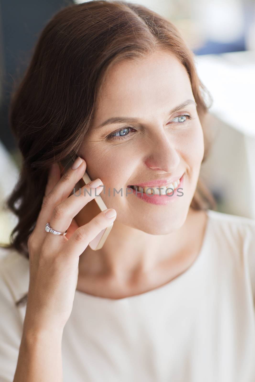 people, women, business and lifestyle concept - happy woman calling on smart phone at restaurant