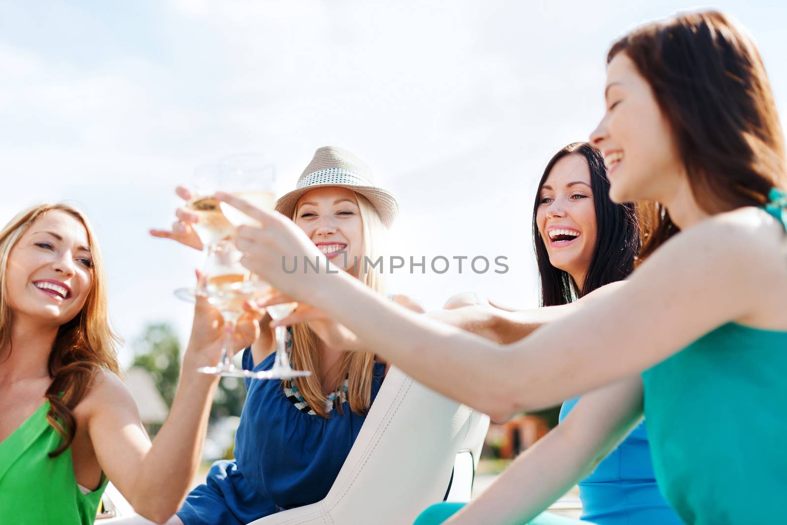 summer holidays and vacation - girls with champagne glasses on boat or yacht